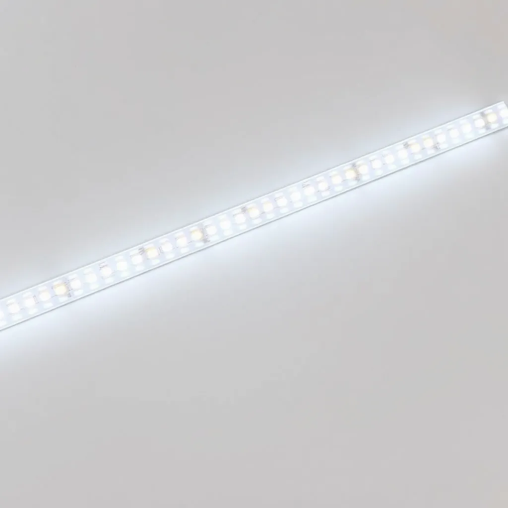 Two pieces of LED strip lighting joined together by a small plastic connector clip on a white surface.