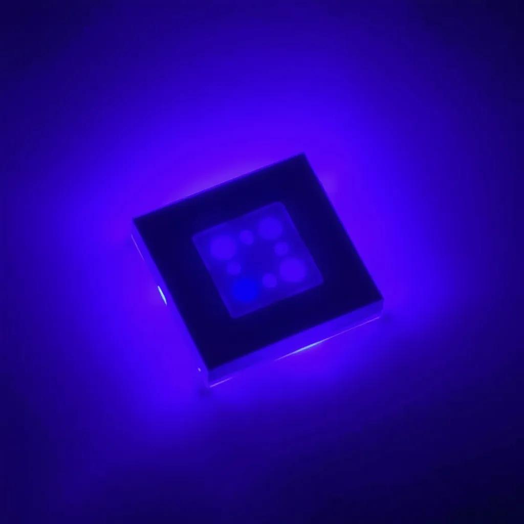 Close-up of a UV LED chip emitting a faint purple light